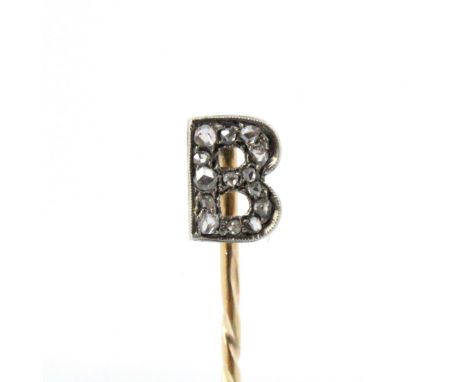 An early 20th century diamond stick pin, the initial ‘B’ head set with mixed rose cut diamonds within white metal milgrain se