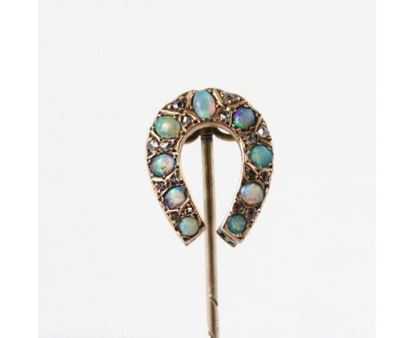 An early 20th century opal and diamond stick pin, the horse shoe shaped head set with nine graduated oval cabochons, with dia