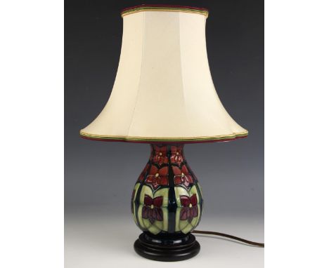 A Moorcroft table lamp in the 'Violet' pattern designed by Sally Tuffin, of baluster form set to a turned wooden base, 22cm h