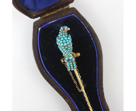 A 19th century turquoise set bird stick pin, the eagle designed head set throughout with cabochon turquoise stones and red st