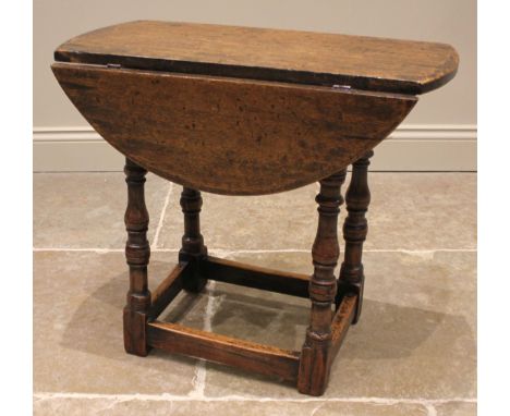 An 18th century style oak drop leaf occasional table, late 19th century, the circular drop leaf top upon bobbin and baluster 