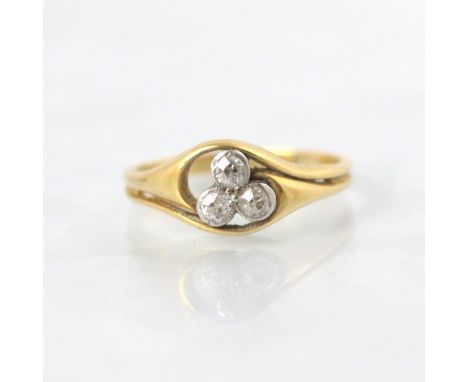 An early 20th century diamond ring, the three old cut diamonds in clover design within white metal milgrain setting edge lead