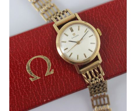 A 9ct yellow gold Omega wristwatch, the circular silver coloured dial with baton markers, set to plain polished case, 2.5cm w