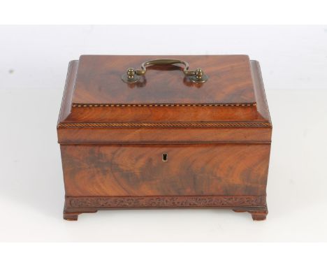 19th century flame mahogany tea caddy of casket form with fret carved band, raised on squat ogee bracket feet, the top openin