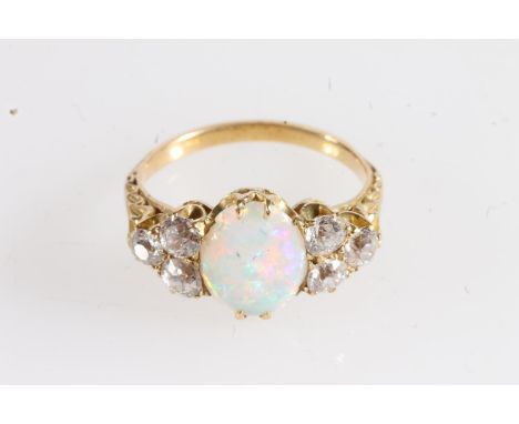 Unmarked yellow metal opal and diamond seven stone ring, the large oval opal flanked by trios of 0.1-0.25ct diamonds, estimat