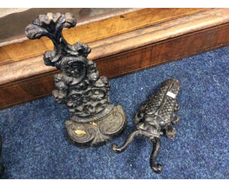 A bronze door stop together with a boot claw.