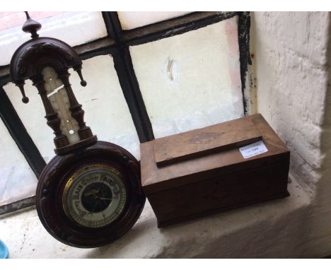 A mahogany tea caddy together with a wall mounted barometer.