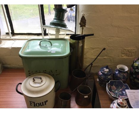 An enamelled green bread bin as well as a flour tin, with copper measures and industrial light.