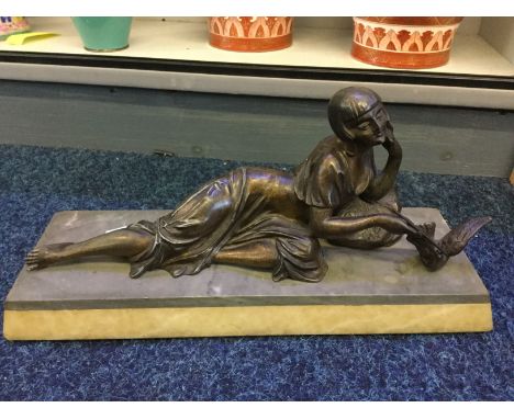 A bronze hollow reclining figure with dove on a marble base.