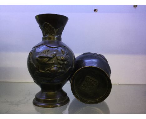 A pair of bronze oriental vases with bird and flower scenes.