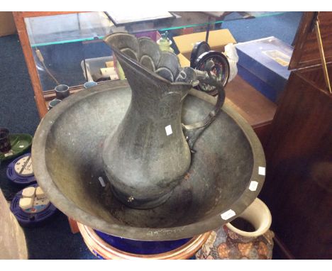 A bronze water jug and basin with hand tooled decoration and Arabic markings.