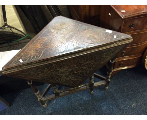 An oak corner gate leg table with carved top.