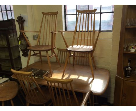 A light elm ercol dining table together with six dining chairs.