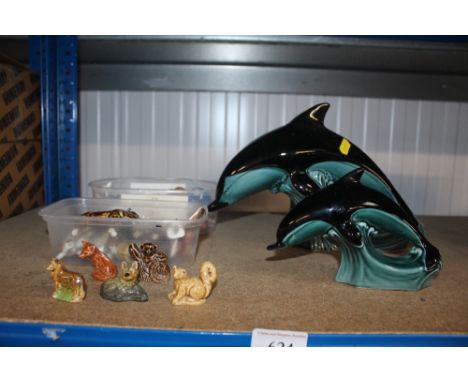 Three Poole figures in the form of dolphins and a quantity of small figurines 