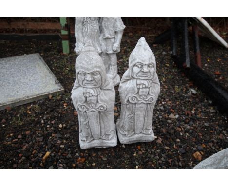 A pair of cast concrete garden ornaments in the form of gate keepers 