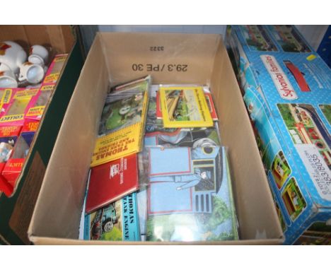 A box containing various Thomas the Tank Engine books and a duvet cover set