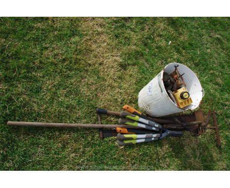 A bin of tools, mincer, three hedge shears, two hooks, a rake, cross-cut saw, sickle and mattock type tool.