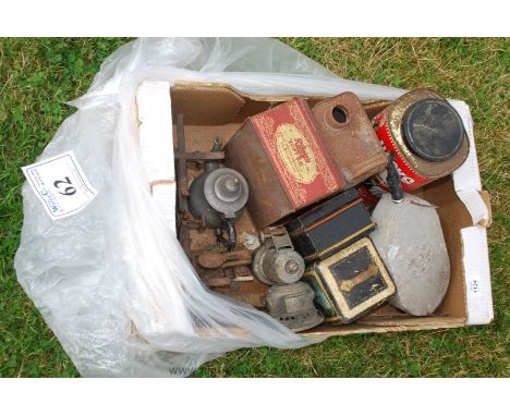 A box of oddments including a carbide bicycle lamp, a letter embosser, a hole punch, a bulk-head light, a small pewter teapot