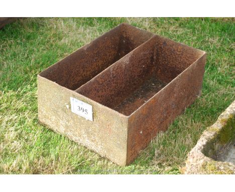 A cast iron two-compartment planter/feed trough. 