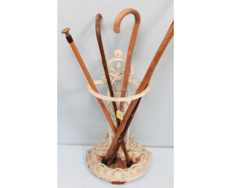 A Victorian white painted cast iron stick stand with five assorted walking sticks