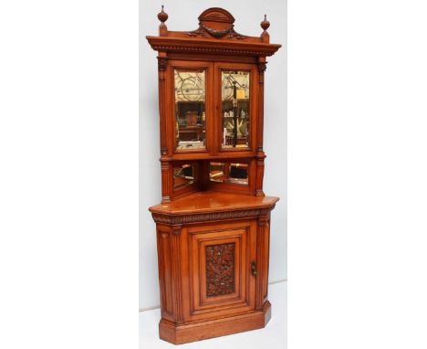 A good quality Edwardian oak standing corner cabinet, with classical cornice above a pair of beveled mirror doors flanked by 