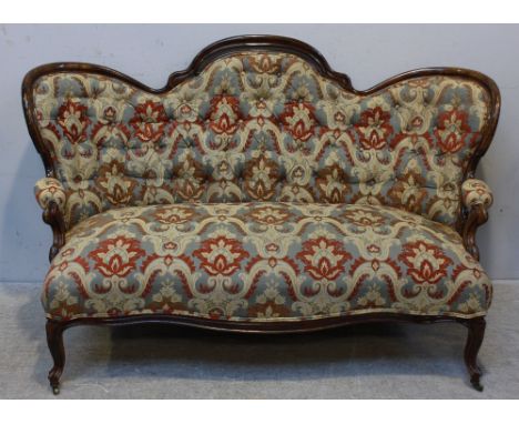 A Victorian walnut-framed large sofa, with shaped and scrolled wing- back, scrolled arms and supports, with new deep-button b