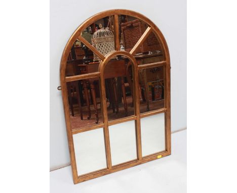 A modern gilt wall mirror in the form of an arched window with individual mirrored plates. 105 x 74 cm.