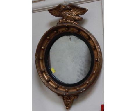 A small 18th century style circular gilt wall mirror, with eagle finial, the frame mounted with orbs. 63 cm high, and another