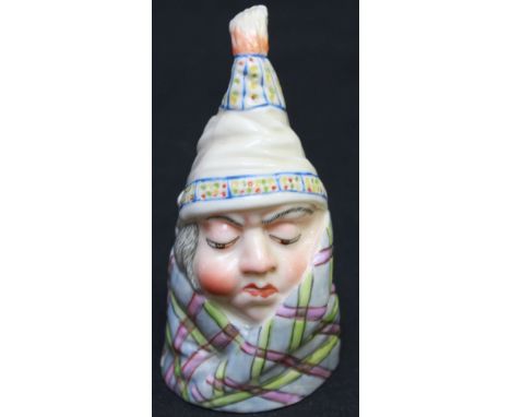 A Royal Worcester porcelain candle snuffer of a man wrapped in a blanket. Mark in puce to interior