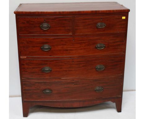 A Victorian mahogany bow front chest of drawers, with two short and three long drawers with oval brass handles and supported 