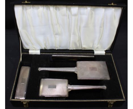 An engine turned silver backed dressing table set of mirror, brush, and comb and clothes brush with case