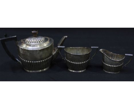 A Victorian silver three piece tea set, hallmarked Sheffield 1892, of semi-fluted form with ebony handle to the teapot. Maker