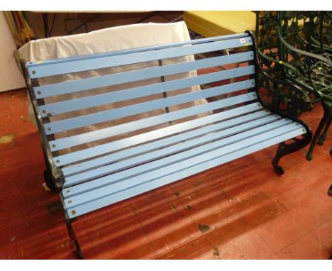 Garden bench with blue painted slats and black cast metal ends
