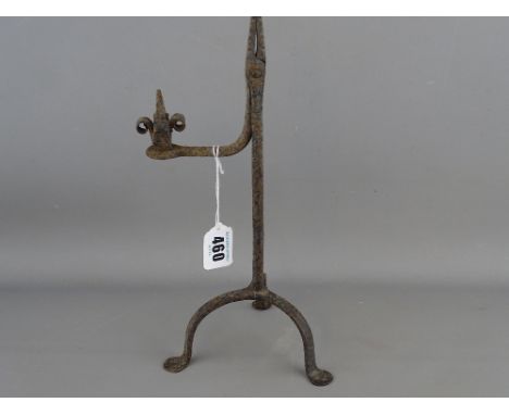 Late 18th Century rush light holder on a tripod base and with interesting scrolled handle