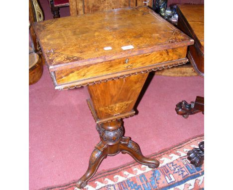 A Victorian inlaid walnut work box on carved column and tripod supports