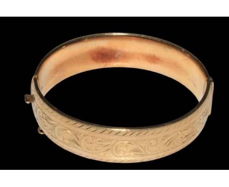 9 carat gold bangle, half engraved with scrolling foliage, 6.5cm across.