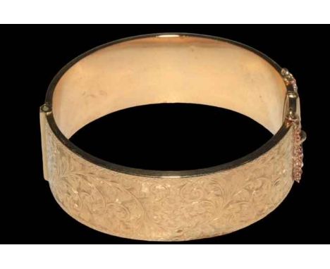 9 carat gold bangle, half engraved with scrolling foliage, 6.5cm across, boxed.