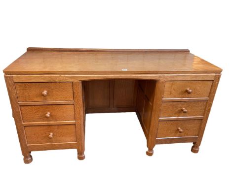 Robert Thompson of Kilburn 'Mouseman' adzed oak six drawer kneehole desk, 74.5cm by 137cm by 50cm.