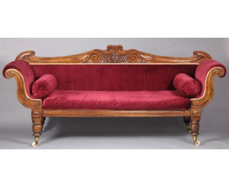 A Victorian mahogany three-seater sofa with scroll ends &amp; carved back-rest, upholstered crimson velour, on turned taperin