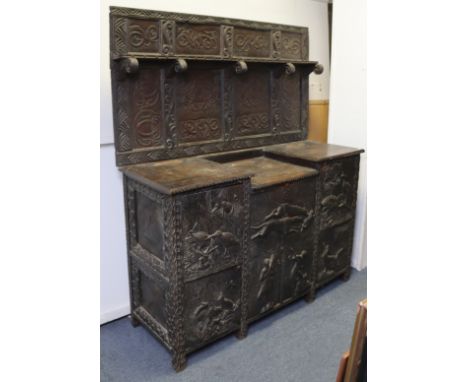 A late 19th century oak side cabinet with raised back, relief-carved with celtic scrolls, hunting scenes, etc., the lower par