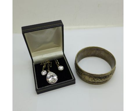 A slave bangle and a silver pear shaped stone pendant and chain with a pair of earrings 
