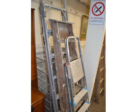 A wooden folding step ladder and two folding aluminium stepladders