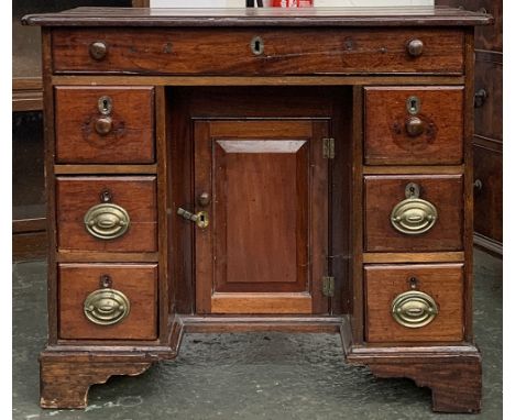 A kneehole dressing table, single drawer over kneehole cupboard, flanked by six drawers, on bracket feet, 82x52x71cmH 