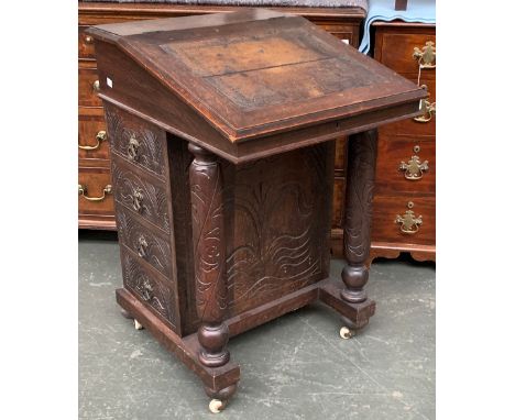 A carved oak davenport desk, on ceramic casters, 52cmW 