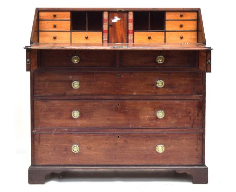 A George III mahogany bureau, the fall front opening to a fitted interior above an arrangement of two short and three long gr