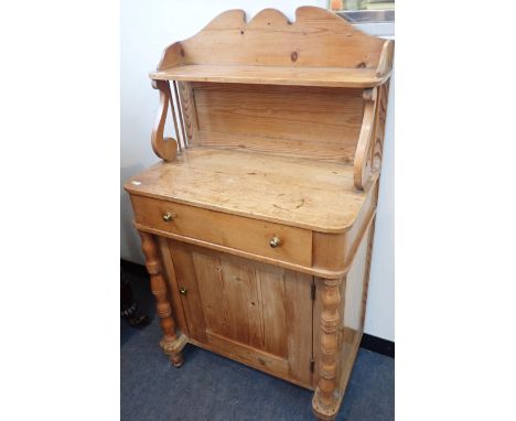 A SMALL EARLY 19th CENTURY STRIPPED PINE CHIFFONIERwith shelf with scrolled supports (one spindle broken), over a drawer and 