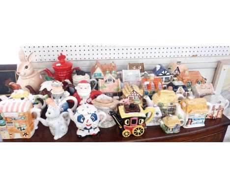 A COLLECTION OF NOVELTY CERAMIC TEAPOTSmany in the form of houses, shops and other domestic buildings, along with animals etc