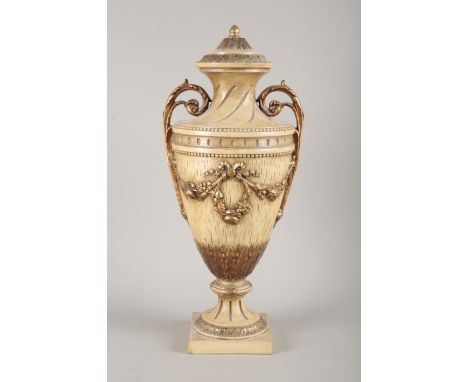 A LARGE CERAMIC URNof 18th Century style modelled with swags and gilded to highlights on a tan ground, 60cm high