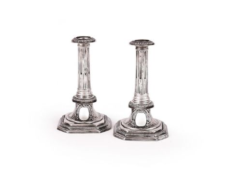 A PAIR OF QUEEN ANNE SILVER CANDLESTICKS RICHARD SYNG, LONDON 1703 With gadrooned and canted corner sconces, slightly taperin