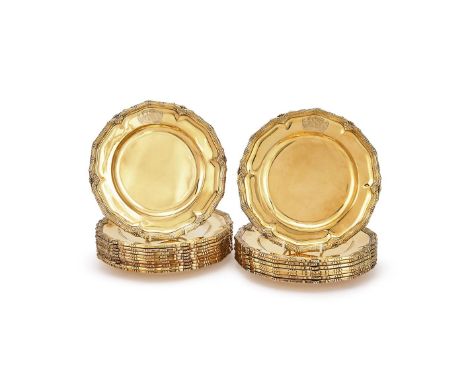 A SET OF EIGHTEEN SILVER GILT SHAPED CIRCULAR PLATES TESSIERS LTD., LONDON 1927 With reed and foliate borders, engraved with 
